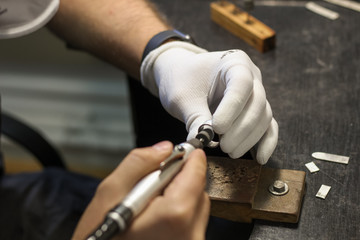 A jewelry master is working to create a silver ring