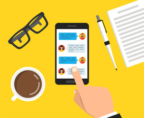 Hand holding smartphone with text messaging on the screen. Сup of coffee, notebook with pen and glasses lay on the table. Vector flat illustration.