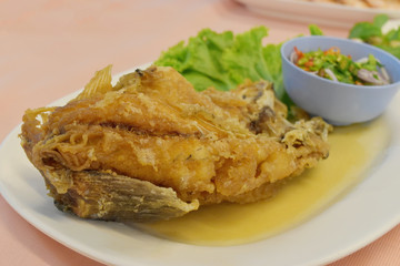 Fried snapper with sweet fish sauce on the plate.