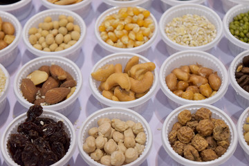 Cereal grains, seeds, beans on white plastic plate.