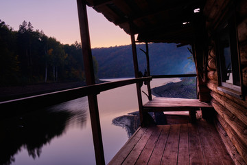 House hunting on the shore of the lake at sunset . Log home, lake sunset