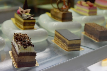 Bread cakes with whipping cream, chocolate and strawberry in bakery shop glass display. for happy birthday.