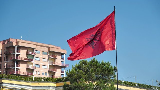 Slow motion, national flag of Republic of Albania. Red flag with silhouetted black double-headed eagle in center