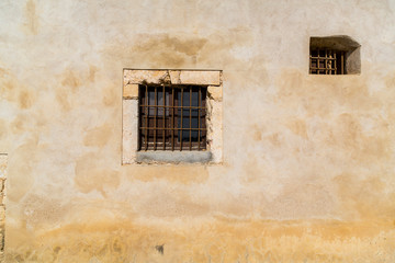 Small barred windows on old Spanish wall