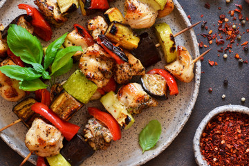 Barbecue of chicken on skewers with vegetables on stone background. Picnic.