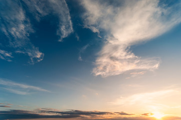 Fototapeta na wymiar Dramadic Sunset Sky blue and orange light of the sun through the clouds in the sky
