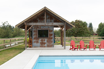 Outdoor suburban pool with a rustic barn as a poolhouse