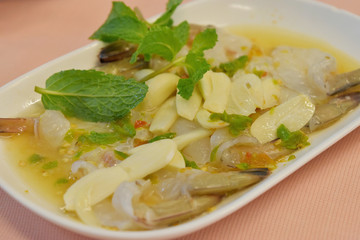 Raw shrimp in fish sauce and spicy sauce with vegetable on plate.