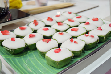 Thai dessert made from flour with coconut and sugar on banana leaf.