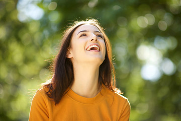 Close up happy young woman laughing in park