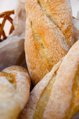 three fresh baguettes lie in a wicker basket