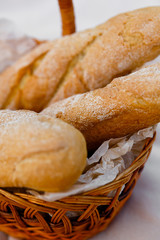 three fresh baguettes lie in a wicker basket