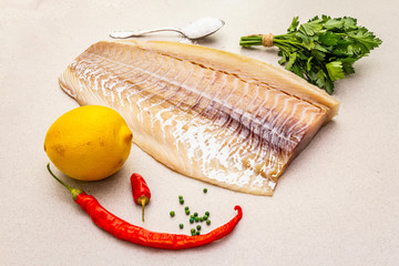 Raw cod loin fillet with lemon, sea salt, chili and cayenne pepper, parsley