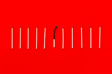 Symbol of danger with matches on red background top view