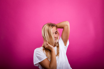 blonde in white shirt isolated against pink background
