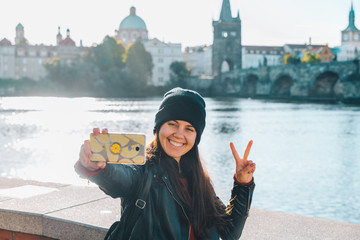 woman taking selfie with charles bridge on background