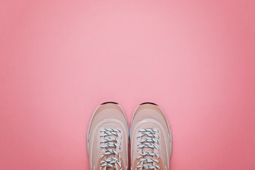 Unbranded modern sneakers on a pink background. Top view.