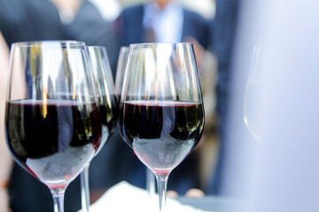 Red wine in crystal cups at business event