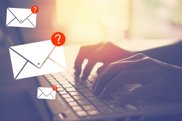 Woman hand using keyboard in cafe shop with red question mark email flying abstract background. Technology business concept and finance risk beware concept.