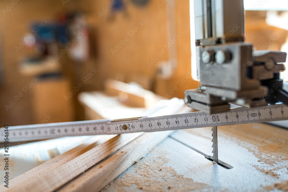 Wall mural Wood measurer on band saw table , cutted wood pieces, shallow depth of field, copy space.