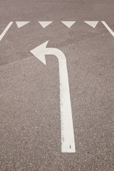 Wei&szlig;er Pfeil auf Stra&szlig;e zeigt abbiegen. Road sign arrow directing turn.