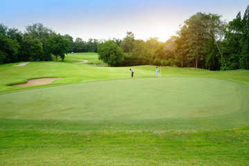 The evening golf course has sunlight shining down at golf course in Thailand