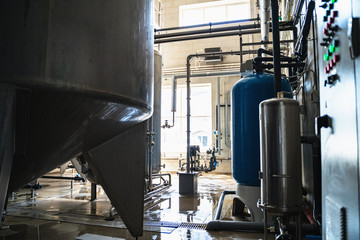 Drinking water factory or plant production, industrial interior. Large metal tanks for filtering and potable water treatment from well