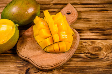 Cutting board with chopped mango fruit on a wooden table