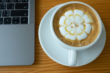 White cup of coffee on wooden background