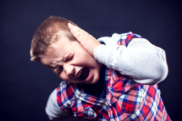 A boy with strong ear pain. Children, healthcare and medicine concept