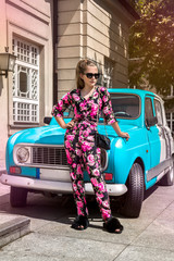 Fashionable stylish young girl wearing trendy floral outfit and stands next to the car - Image