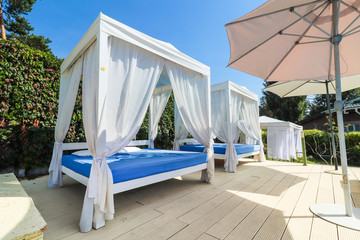 pool with clear water and sunbeds with bungalows near the hotel.