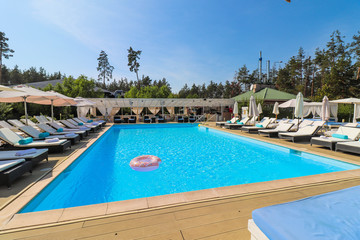 pool with clear water and sunbeds with bungalows near the hotel.