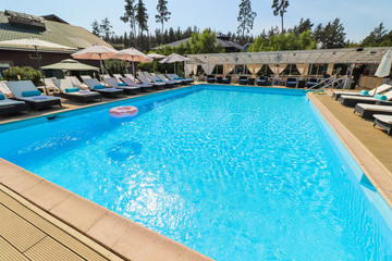pool with clear water and sunbeds with bungalows near the hotel.
