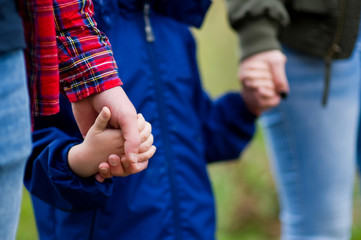 Parents hold their hands. Close-up, without faces. Focus on the hands