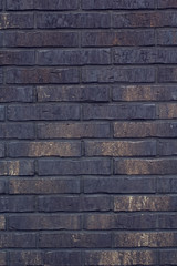 Black bricks background. A part of wall of the building