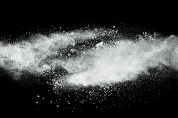 White powder explosion cloud against black background.White dust particles splash.