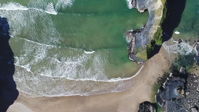 Overhead aerial, waves crash on Ballybunion Beach