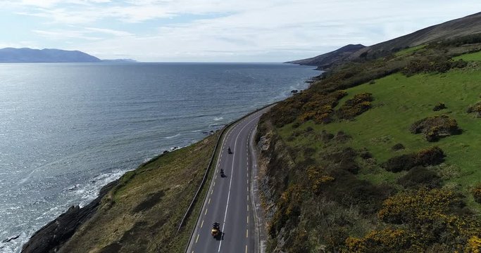 Motorcycles drive down Dingle Peninsula road, aerial