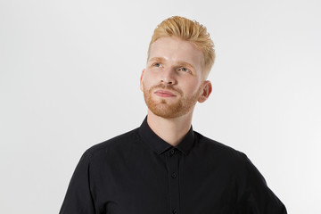 Young entrepreneur Generate Business Ideas. Close up of thinking Man in black shirt isolated with copy space. Self improvement and serious male face. Redheaded guy with red beard and stylish hairstyle