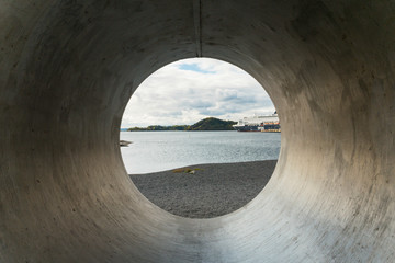 View through concrete pipe on shore