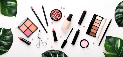 Floral flat lay composition of monstera leaves with cosmetics