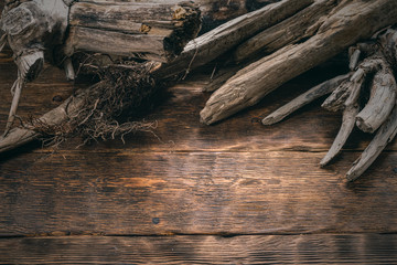 Old dried wooden branches on brown wooden board background with copy space.
