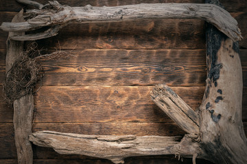 Old dried wooden branches frame on brown wooden board background with copy space.