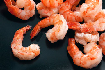  Pile of frozen king prawns on blue background.