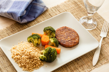 delicious couscous with steamed vegetables and vegetarian steak made of figs with goat cheese and mango