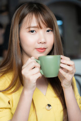 Pretty female drinking coffee in cozy cafe during lunch