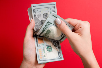 Businesswoman's hands counting one hundred dollar bills on colorful background. Salary and wage concept. Top view of Investment concept