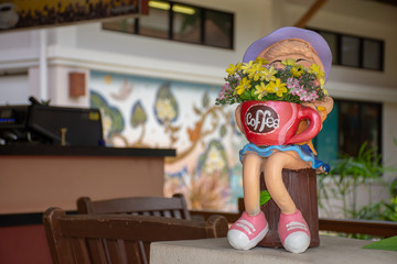 .Ceramic doll holding a coffee cup