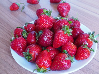 strawberries in a plate on a wooden table